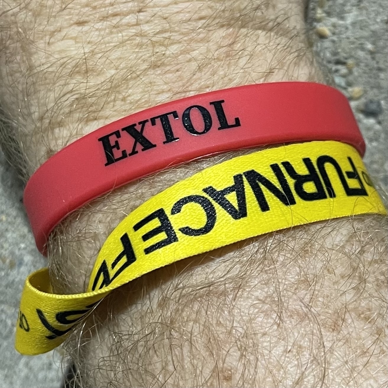 red Extol wristband and yellow Furnace Fest wristband